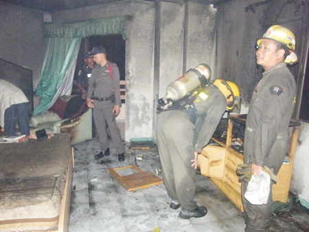 Firefighters inspect damage inside a unit at Khiang Talay Condominium on Pratamnak Soi 6.